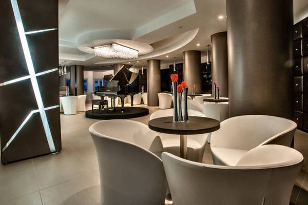 Lounge-Bereich des Grand Hotel Resort Ma&Ma mit Klavier und weißen Möbeln.