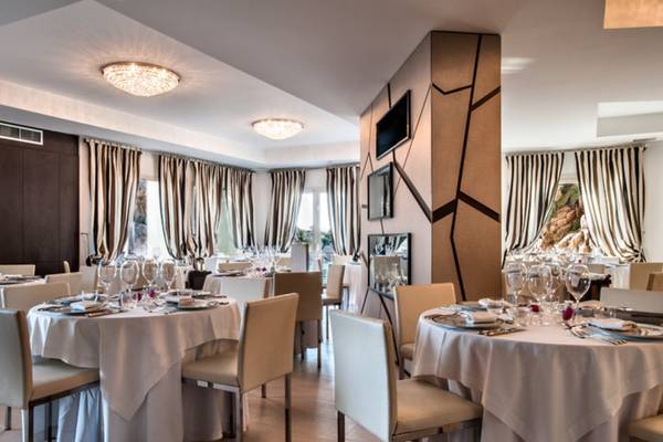 Innenbereich des Restaurants im Grand Hotel Resort Ma&Ma mit elegant eingerichteten Tischen und Stühlen.