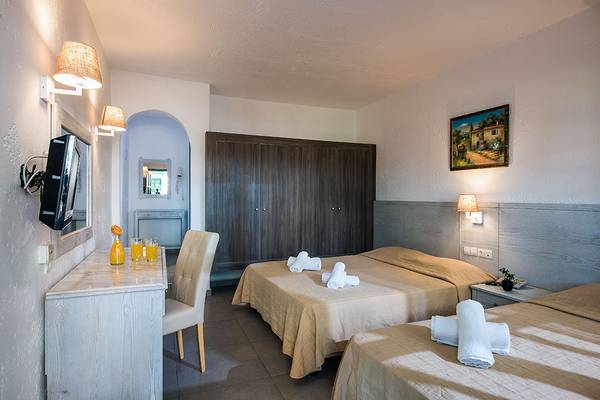 Doppelzimmer im Stella Village Hotel & Bungalows mit zwei Betten, Fernseher, Schreibtisch, Stuhl und Kleiderschrank.