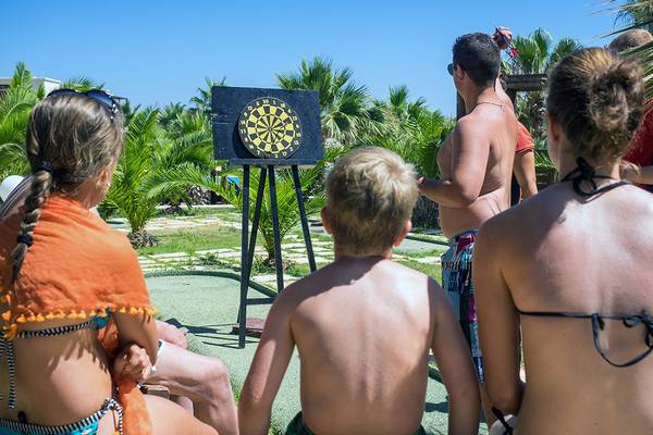 Familie spielt Dartwerfen im Freien im Stella Village Hotel & Bungalows.
