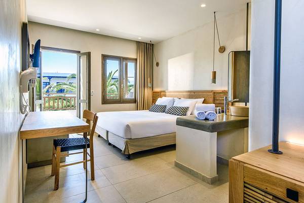 Ein modernes Hotelzimmer mit Blick auf den Balkon und einen Garten