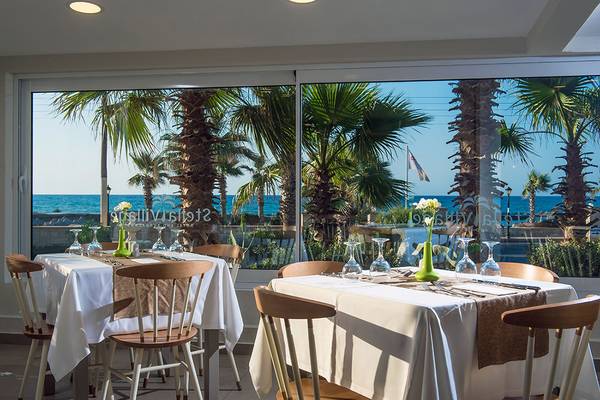 Innenansicht des Restaurants des Stella Village Hotel mit Blick auf den Ozean.