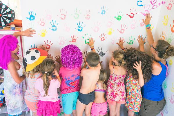 Kinder mit bunten Handabdrücken an einer Wand im Stella Village Hotel & Bungalows.