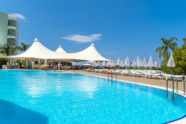 Außenpool des Grand Belish Resort Hotel & Spa mit großen weißen Zelten und Sonnenliegen.