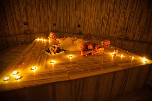 Eine Frau liegt in einer beleuchteten Sauna des Grand Belish Resort Hotel & Spa.