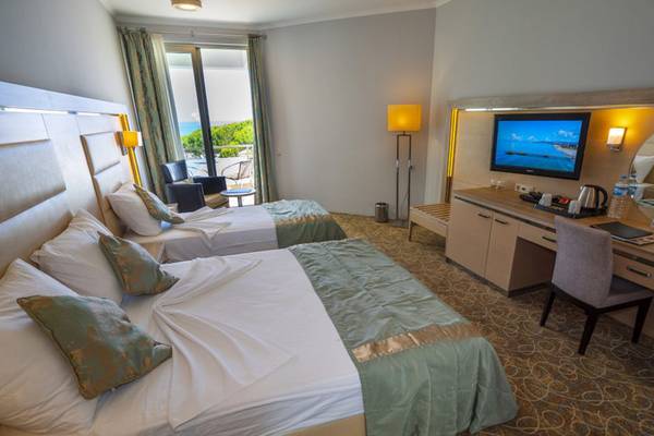 Doppelzimmer im Grand Belish Resort Hotel mit zwei Betten und Aussicht auf das Meer.