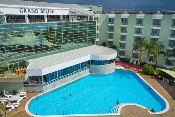 Außenansicht des Grand Belish Resort Hotel & Spa mit Swimmingpool und Sonnenliegen.