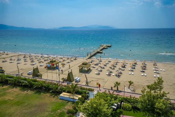 Luftaufnahme des Grand Belish Resort Hotels & Spa Strand mit vielen Liegen und einer Pier