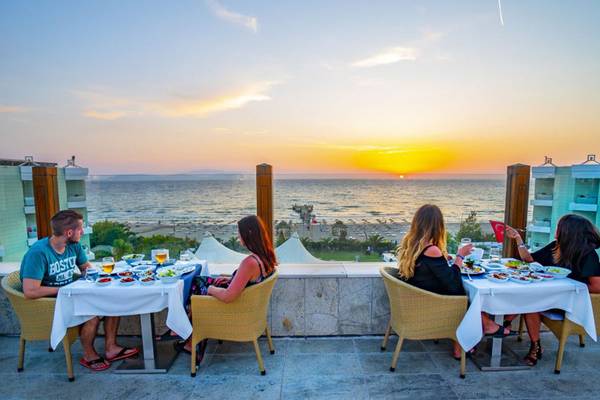 Dinner auf der Terrasse des Grand Belish Resort Hotel & Spa mit Blick auf den Sonnenuntergang über dem Meer.