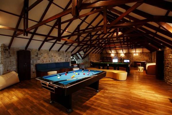 Spielzimmer im Centara Grand Island Resort & Spa mit Billardtischen und Sofas.