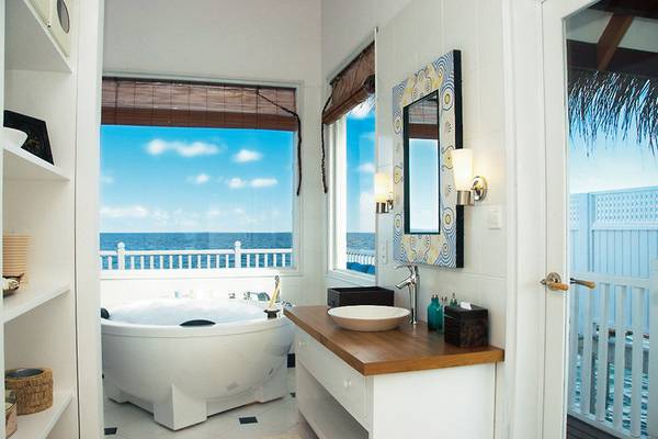Badezimmer im Centara Grand Island Resort mit Blick auf das Meer und eine Badewanne.