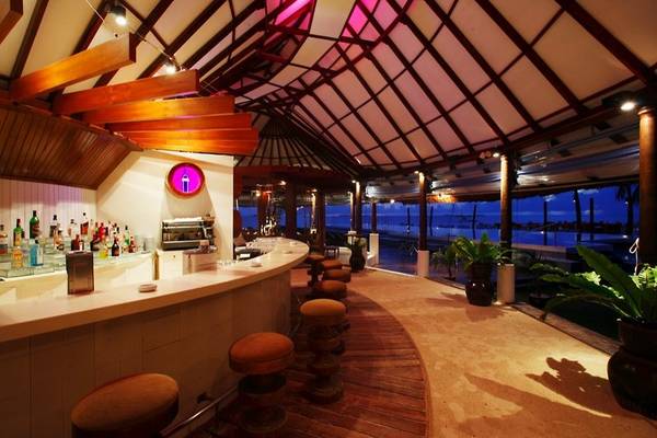 Innenansicht der Bar im Centara Grand Island Resort & Spa mit Holzmöbeln und Pflanzen.