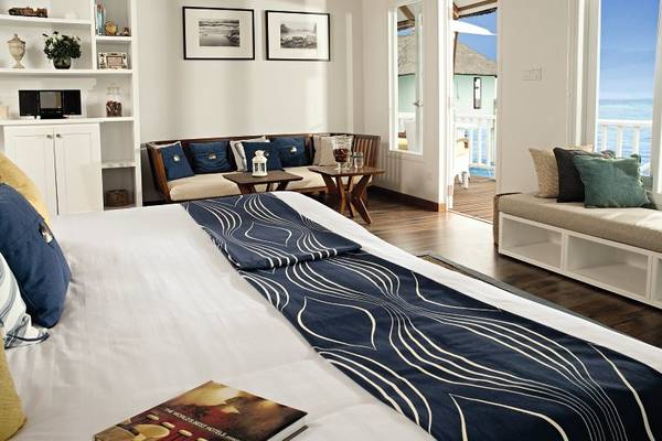 Schlafzimmer im Centara Grand Island Resort mit Bett, Couch und Meerblick.