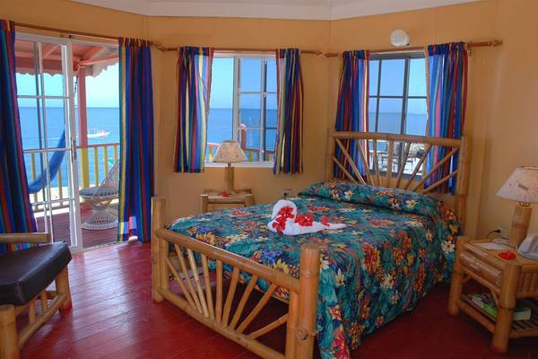 Ein Zimmer im Samsara Cliff Resort mit Blick auf das Meer und bunten Vorhängen.