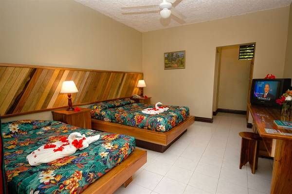 Doppelzimmer im Samsara Cliff Resort mit zwei Betten, Fernseher, Tisch und Deko.