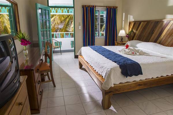 Hotelzimmer im Samsara Cliff Resort mit einem Bett, Balkon und Fernseher.