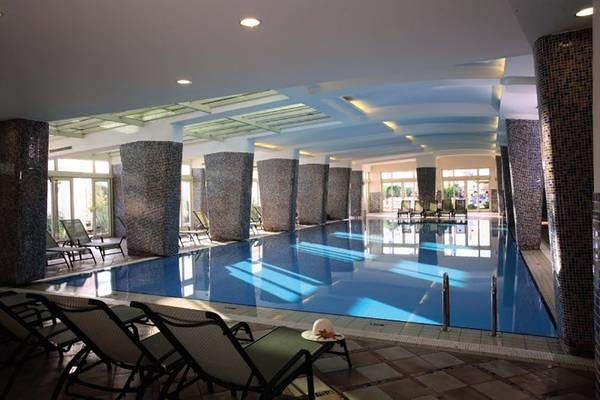 Innenpool des La Blanche Resort & Spa mit Liegestühlen und blauem Wasser
