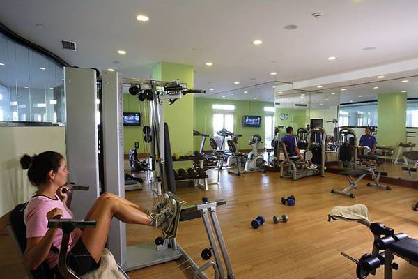 Fitnesscenter im La Blanche Resort mit diversen Geräten und Personen, die trainieren.