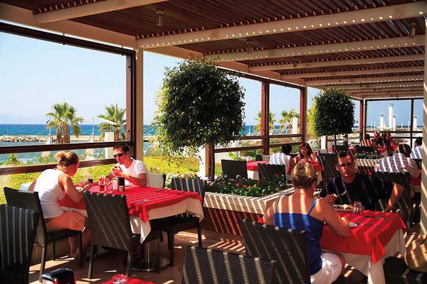 Gäste essen auf der Terrasse des La Blanche Resort & Spa mit Blick auf das Meer.