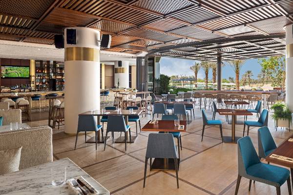 Innenansicht des Restaurants im JA Lake View Hotel mit blauen Stühlen und Tischen.