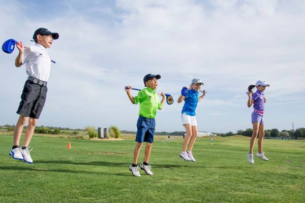 Kinder spielen Golf auf einem Golfplatz am JA Lake View Hotel.