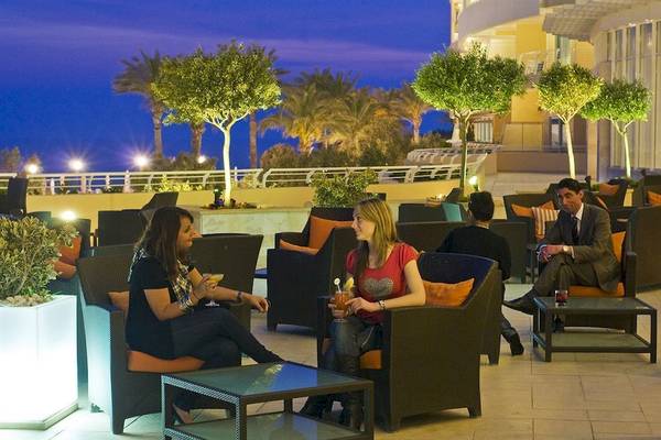Gäste sitzen in der Lounge des Radisson Blu Resorts & Spa, Malta Golden Sands, bei Nacht