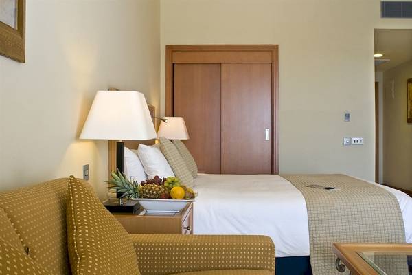 Hotelzimmer im Radisson Blu Resort & Spa, Malta Golden Sands mit Bett, Obstteller und Sofa.