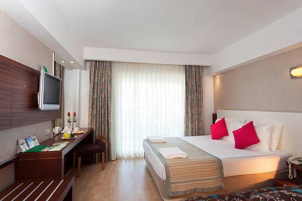 Hotelzimmer im Seher Resort & Spa mit Doppelbett, Schreibtisch, Fernseher und Fenstern.