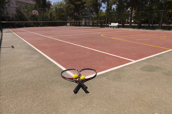 Tennisplatz im Seher Resort & Spa mit zwei Tennisschlägern und Bällen