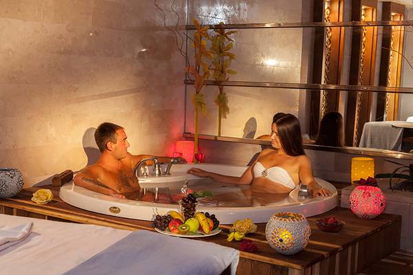 Ein Paar genießt ein romantisches Bad im Whirlpool im Seher Resort & Spa.