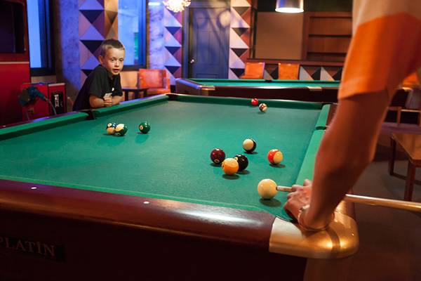 Ein junger mann spielt pool im seher resort und spa mit einem anderen spieler.