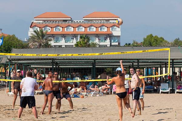 Volleyballspiel auf dem Strand vor dem Seher Resort & Spa mit Teilnehmern und Zuschauern.