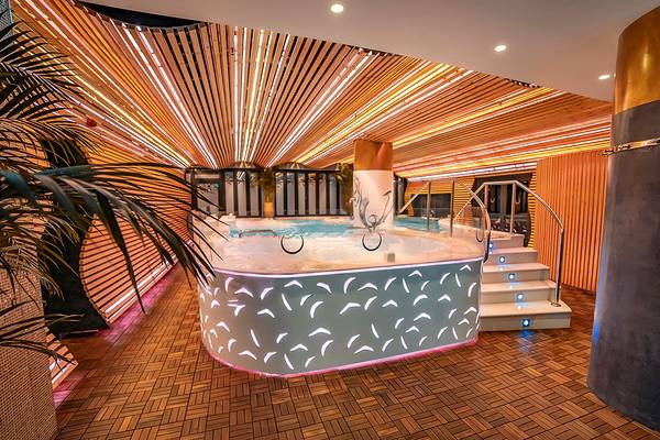 Indoor Whirlpoolbereich im Bohemia Suites & Spa Hotel mit blauen Lichtern und Holzboden.