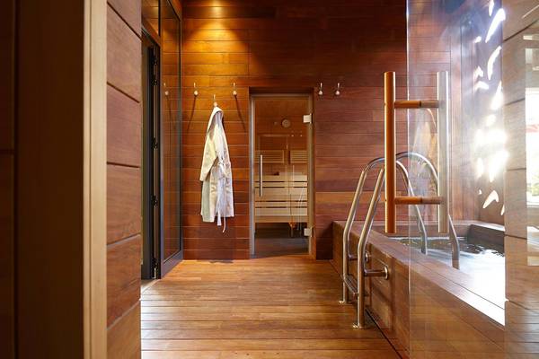 Innenansicht einer Holzsauna im Hotel Bohemia Suites & Spa mit offenen Türen und einem Badebecken.