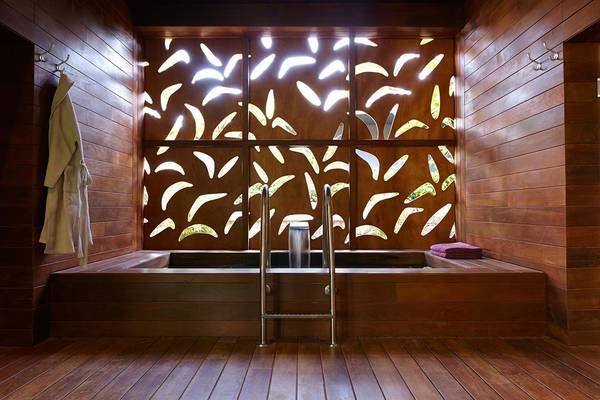 Innenansicht eines Badezimmers der Bohemia Suites & Spa mit Holzwänden und Fenstern.