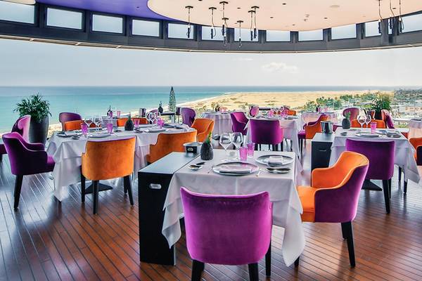 Speisesaal mit Tischdecken und bunten Stühlen im Bohemia Suites & Spa mit Meerblick.