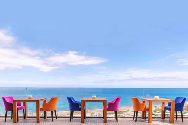 Terrasse mit Tisch und Stühlen mit Ausblick auf das Meer im Bohemia Suites & Spa