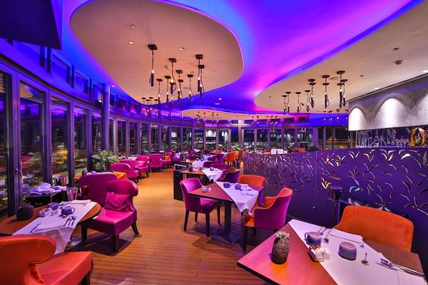Inneneinrichtung des Restaurants im Bohemia Suites & Spa mit violetten und orangefarbenen Möbeln.