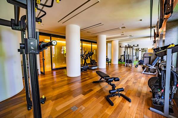 Fitnessraum im Bohemia Suites & Spa mit Holzboden, modernen Geräten und großen Fenstern.