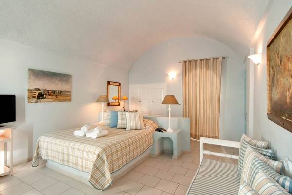Schlafzimmer im Andromeda Villas & Spa Resort mit Bett, Fernseher und Dekor