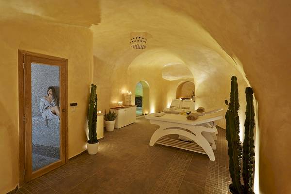 Innenansicht des Spa-Behandlungsraums im Andromeda Villas & Spa Resort mit Behandlungsliegen, Pflanzen und einer Person auf der Liege
