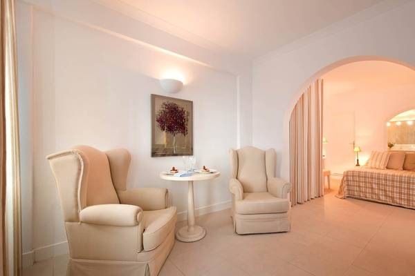 Hotelzimmer mit zwei Sesseln, Tisch und Bett, modernes Design