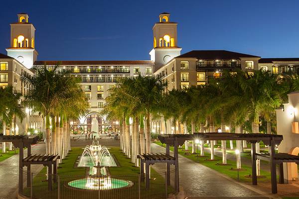 Der beleuchtete Eingang des Lopesan Costa Meloneras Resort & Spa mit Brunnen und Palmen