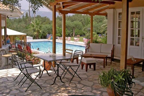 Terrasse des Nefeli Hotels mit Tisch, Stühlen und Blick auf den Pool