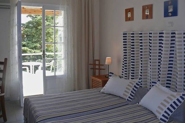 Schlafzimmer im Nefeli Hotel mit Balkonzugang und modernen Möbeln.