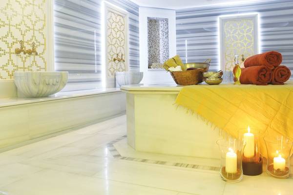 Spa-Bereich im Kempinski Hotel San Lawrenz Malta mit Tisch, Kerzen, Handtüchern und Becken.