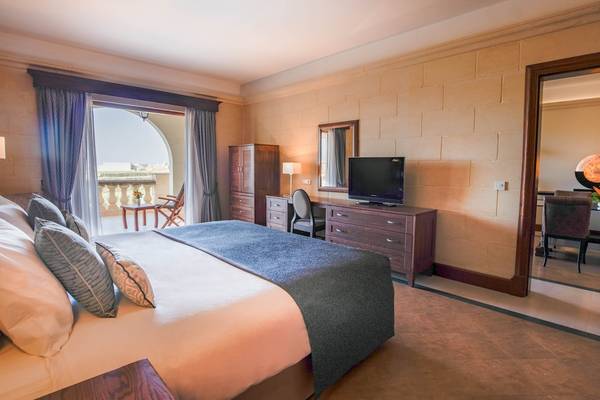 Hotelzimmer im Kempinski Hotel San Lawrenz, Malta mit Bett, Schreibtisch und Fernseher.