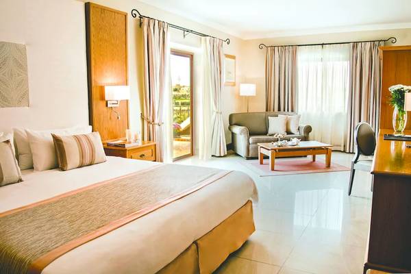 Hotelzimmer im Kempinski Hotel San Lawrenz Malta mit Bett, Sofa und Tisch