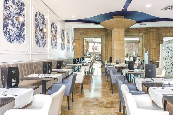 Innenansicht des Restaurants des AluaSoul Costa Adeje Hotels mit blau-weißen Wandmustern und runden Tischen.