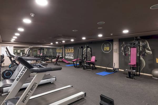 Fitnesscenter im AluaSoul Costa Adeje Hotel mit verschiedenen Trainingsgeräten und Wandmotiven.